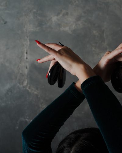 Young adult spanish woman dancing flamenco with castanets on gray vintage background Young adult spanish woman dancing flamenco with castanets on gray vintage background